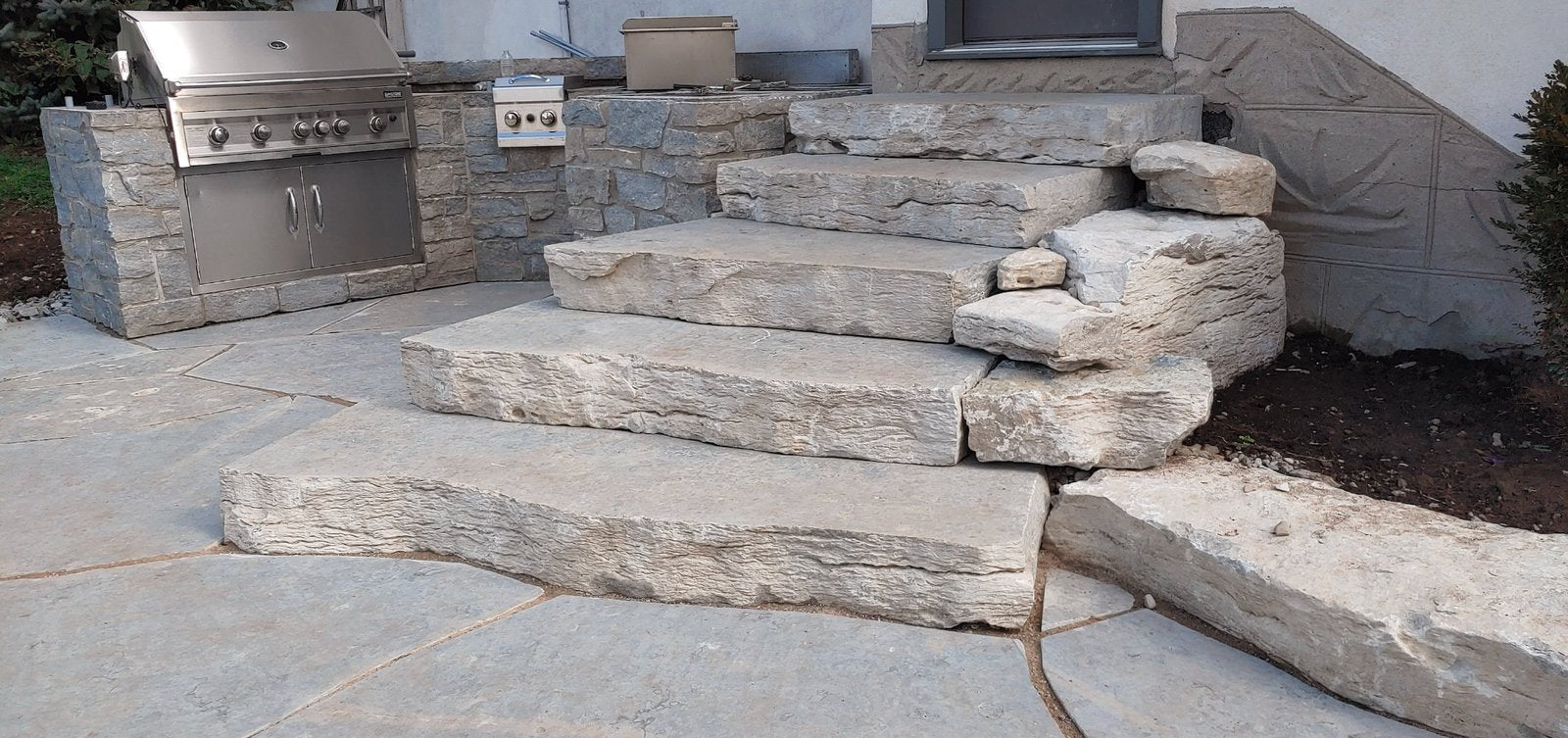 Weatheredge Limestone curved staircase with rock-face steps beside outdoor kitchen