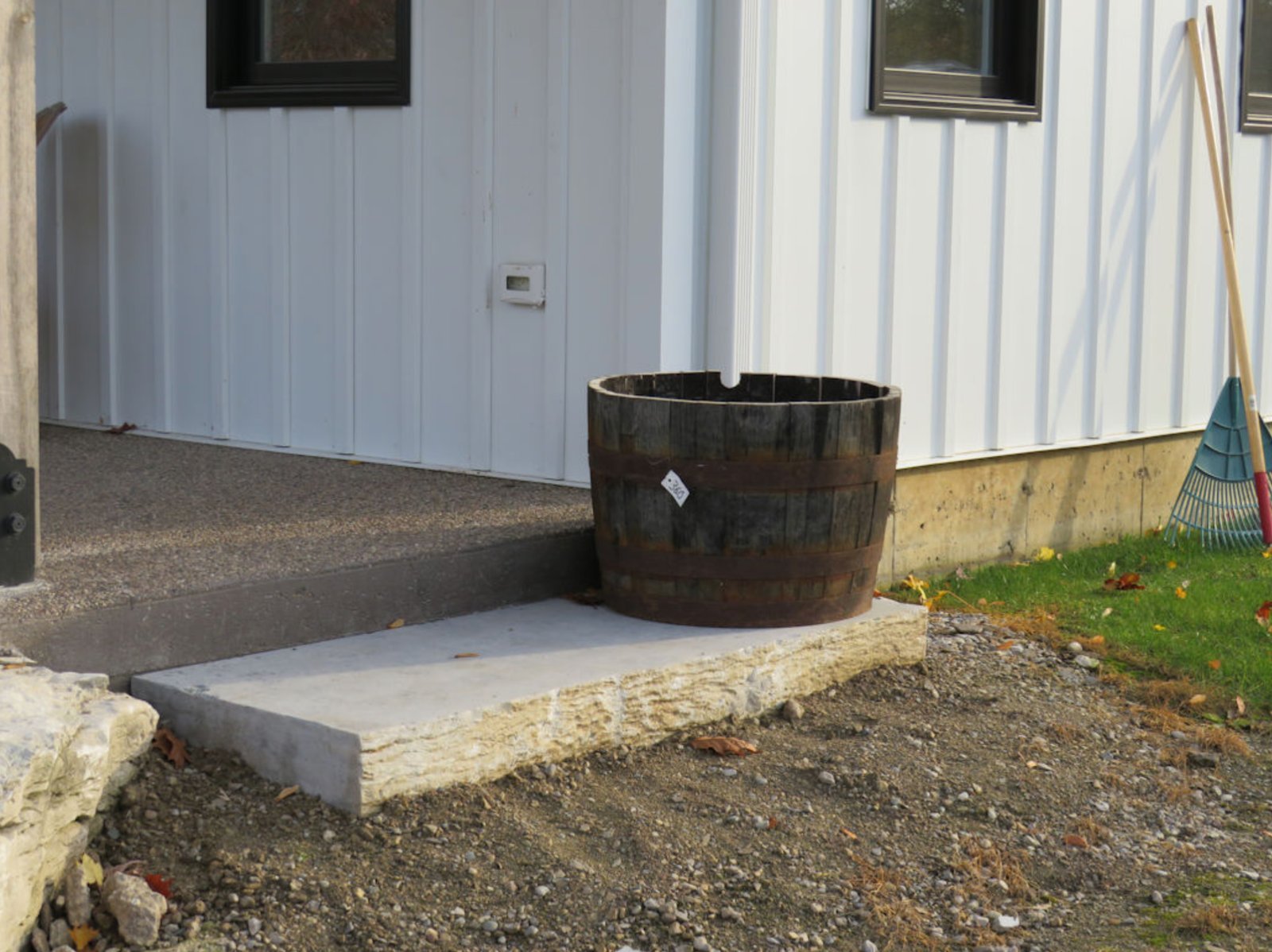 Weatheredge Limestone single-slab step at side entry with whiskey barrel planter