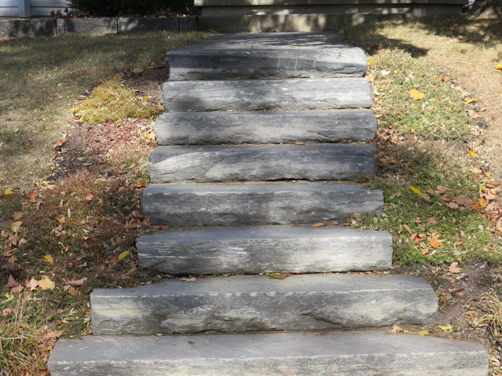 Split-top natural stone steps forming a hand-chiseled long walkway to a home