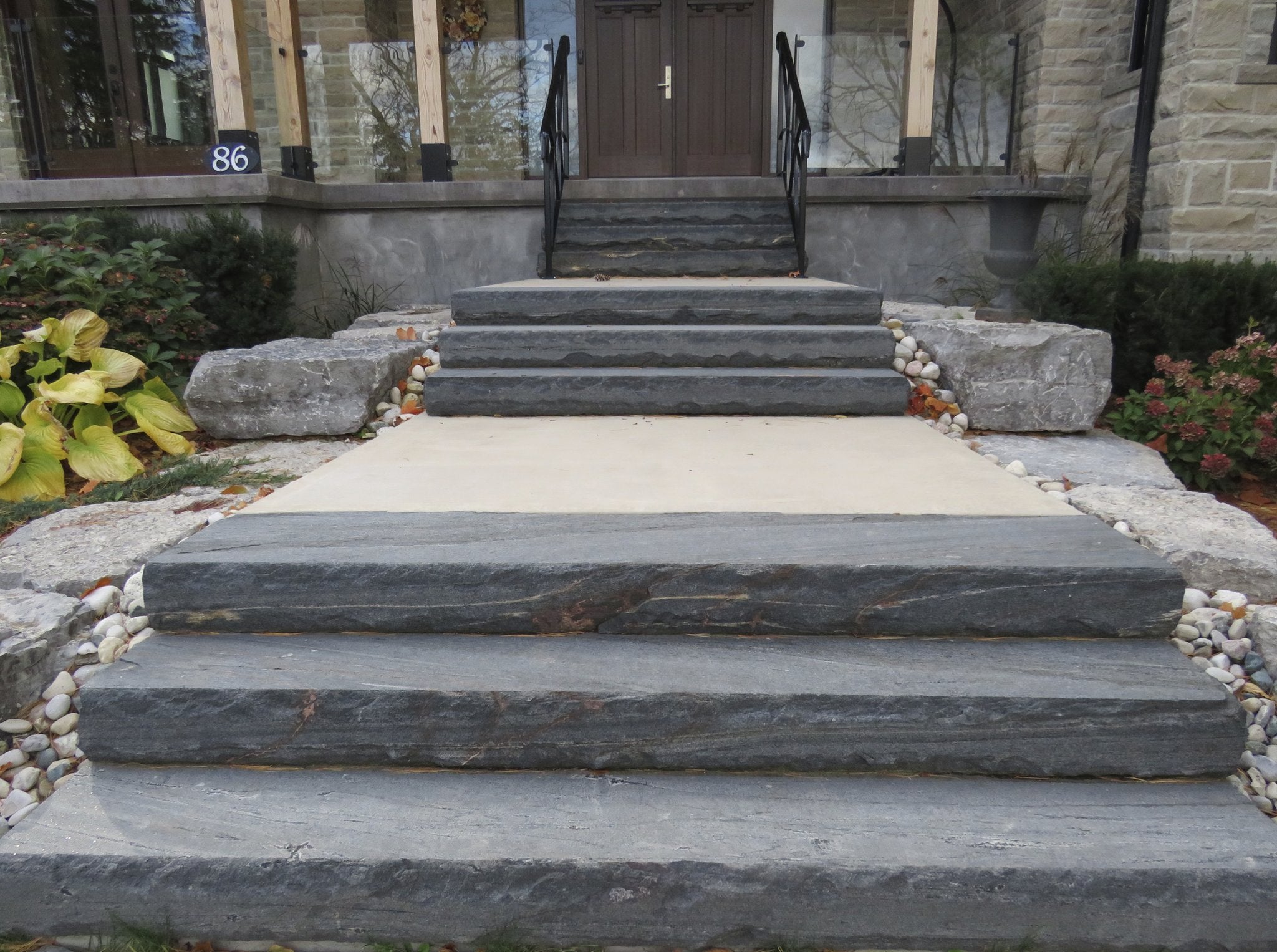 Elite Blue Granite natural stone steps forming a grand dual staircase front entry