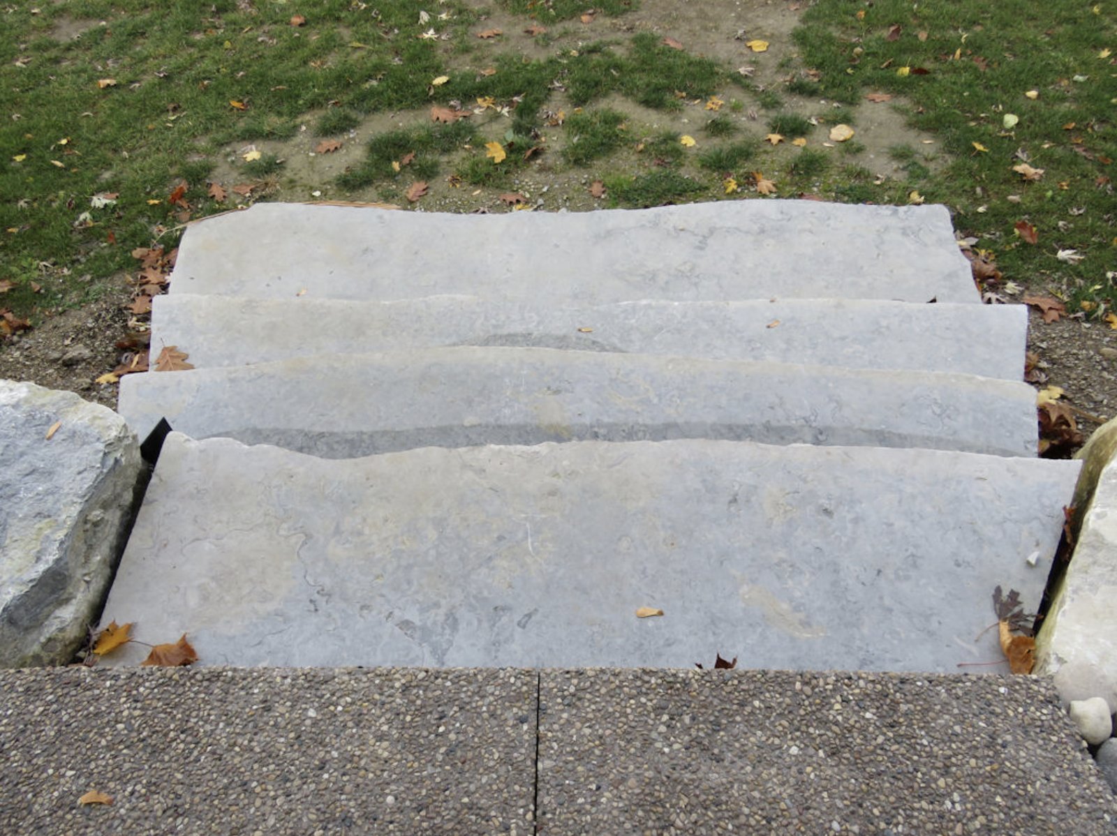 Top-down view of four Weatheredge Limestone natural stone steps installed on lawn