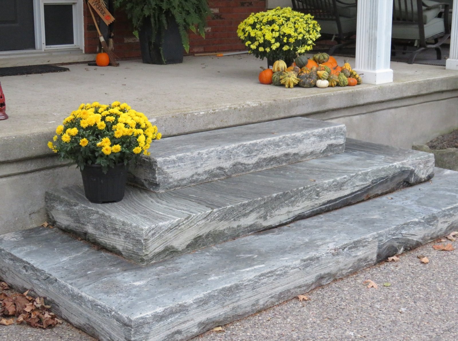 Split-top natural stone steps with rock-faced edge installed as three-step porch entry